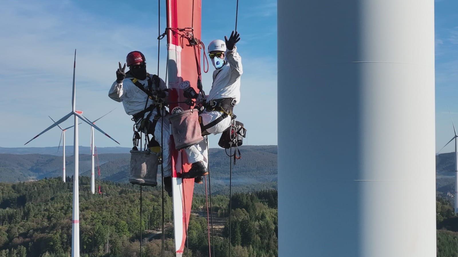 Seilgesicherte Fachkräfte vor einer Windenergieanlage